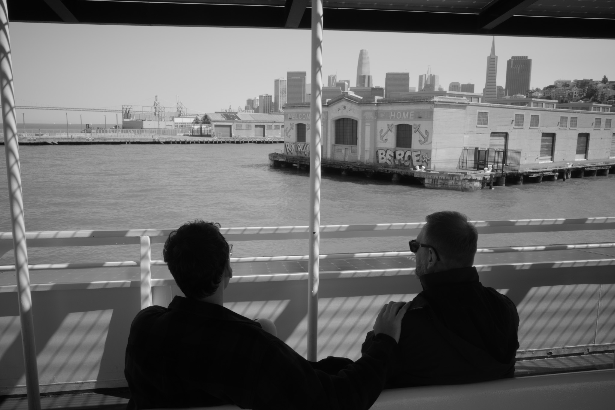 Two silhouettes on a ferry framed against the San Francisco skyline
